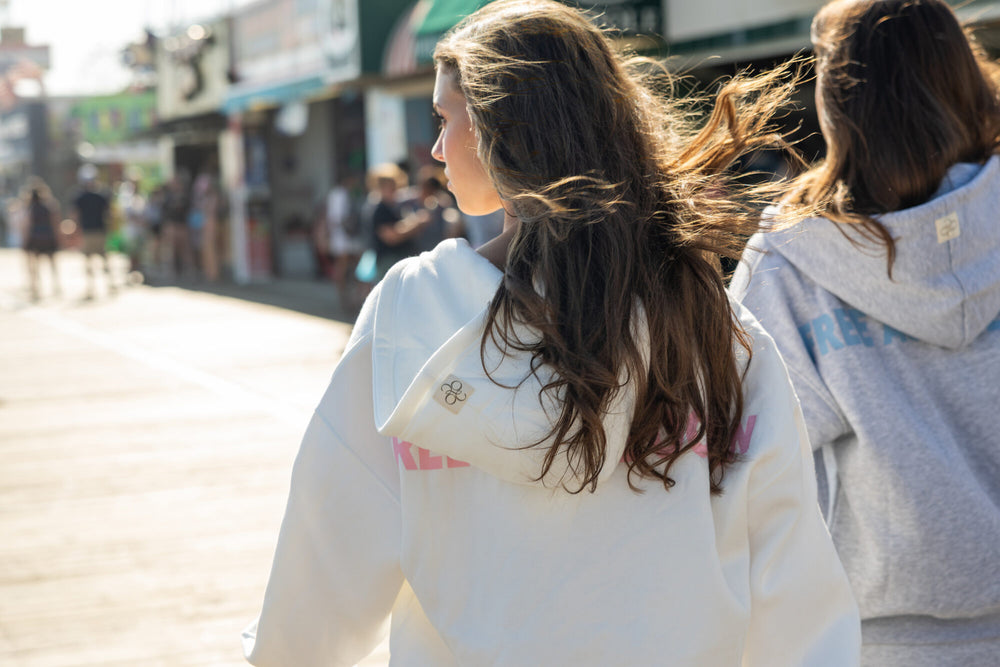 Rear artwork and hood patch on a White Beach Offsure Full-Zip Hoodie on the boardwalk