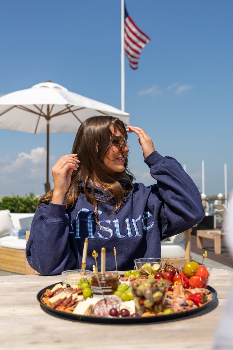 Offsure Patch Pullover in Navy Coast on a rooftop, American flag behind